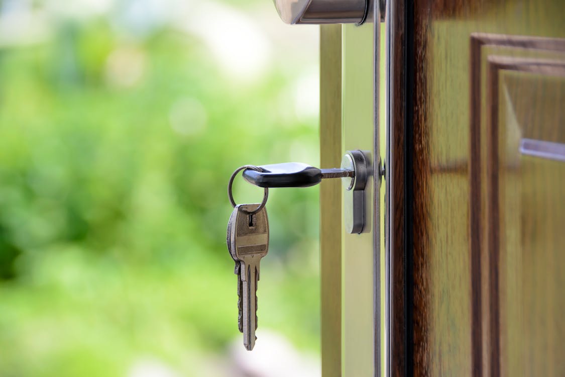 Professional home appraiser wearing a collared shirt stands outside a residential home, carefully examining the siding and...
