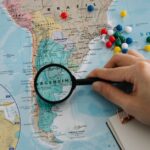 Brightly lit, clean photo of a map with various locations marked by pins, all interconnected by a network of colored strin...