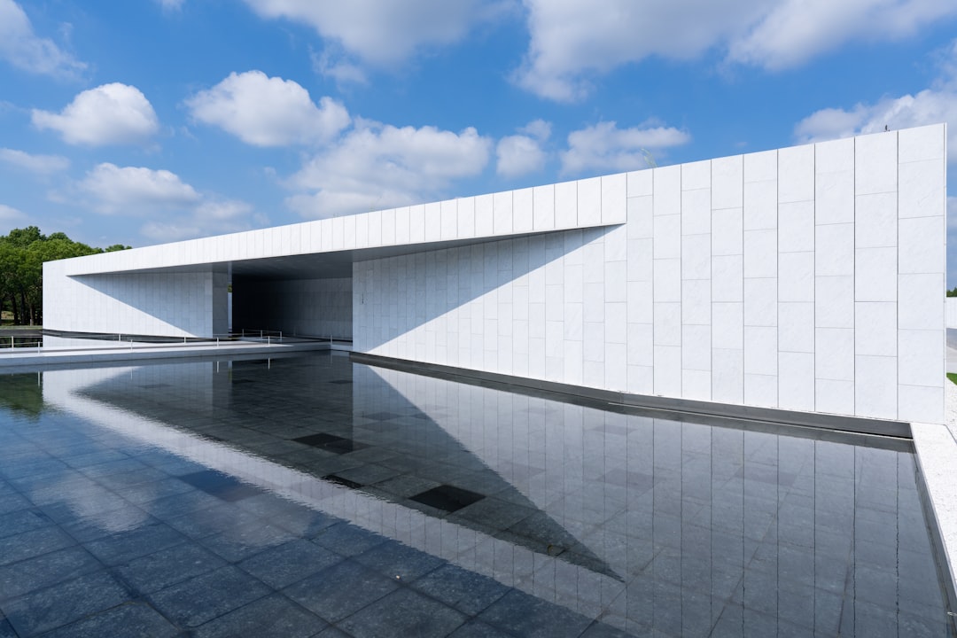 The clean, bright exterior of a modern minimalist home against a clear sky, representing a fresh, streamlined approach to selling real estate.