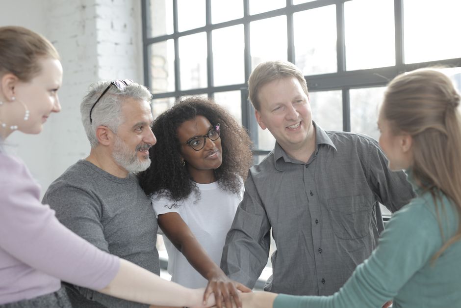 A diverse group of people sitting around a table in a room filled with natural light, collaboratively working on a project, representing local organizations using data for community impact.
