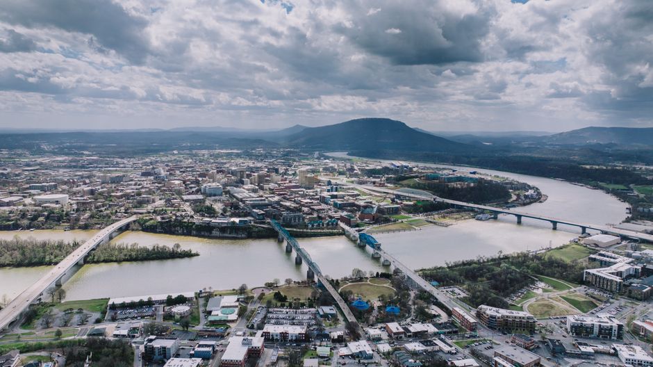Bright, scenic photograph of the Chattanooga, Tennessee downtown skyline and the Walnut Street Bridge on a clear, sunny da...
